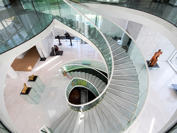 Escalier hélicoïdal en acier et verre dans un atrium lumineux