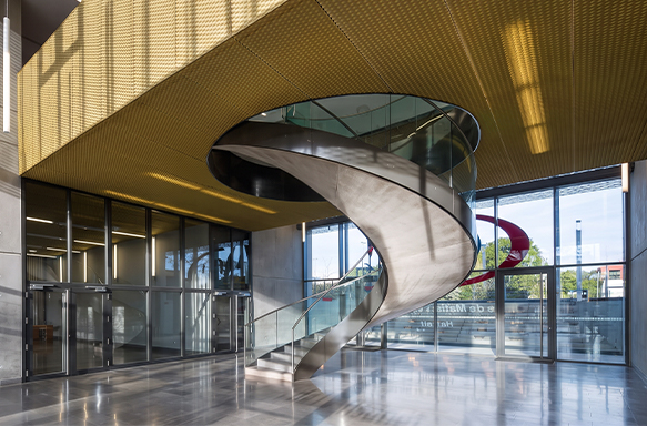 Escalier hélicoïdal en acier et verre dans un atrium contemporain