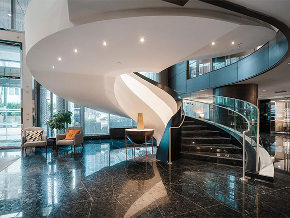 Escalier hélicoïdal blanc sur mesure dans un lobby d’hôtel contemporain