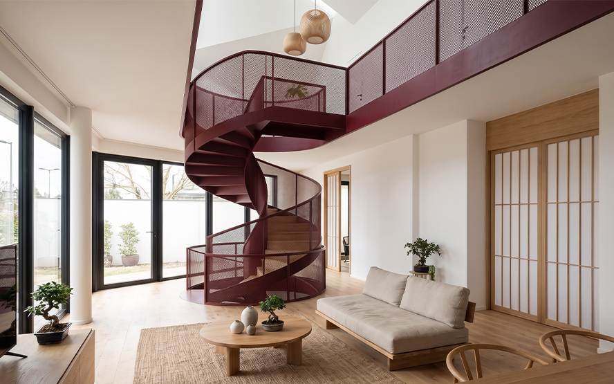 Escalier hélicoïdal bordeaux en métal perforé dans une maison contemporaine