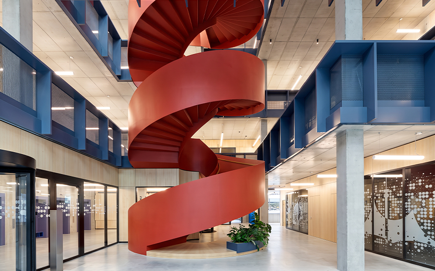 Escalier hélicoïdal rouge métallique sur mesure dans un espace architectural