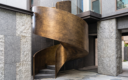 Escalier hélicoïdal sculptural en acier patiné sur mesure